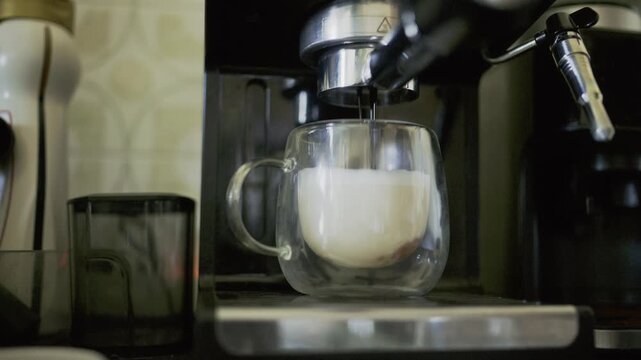 Espresso machine pouring hot coffee into milk
