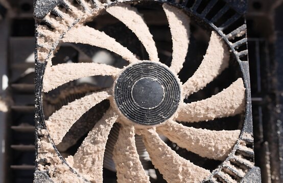 Computer cooling fan covered with dust inside dirty pc case high resolution photo