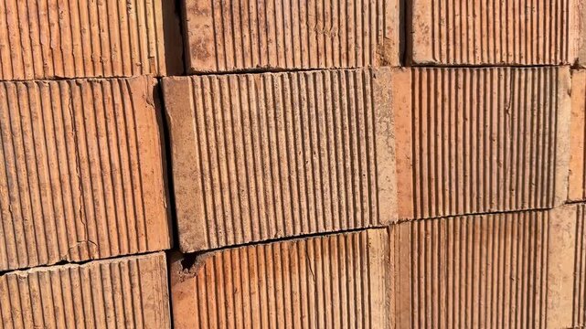 Close-up of textured red clay bricks for construction background or masonry concept