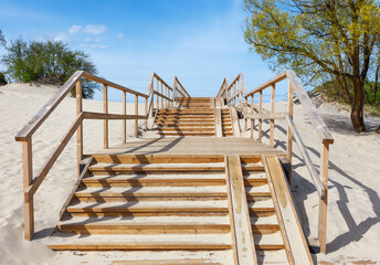 Obraz premium Wooden staircase leading through a sand dune to the sea