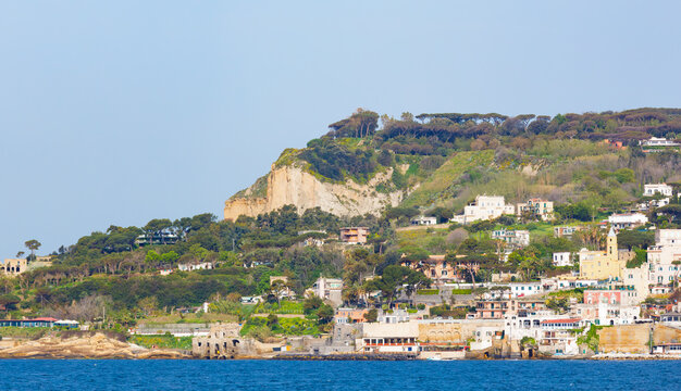 Panoramic view of Marechiaro village seen from sea on Posillipo hill in Naples, Italy. Scenic coastal landscape with colorful Mediterranean buildings nestled on lush green cliffs. 