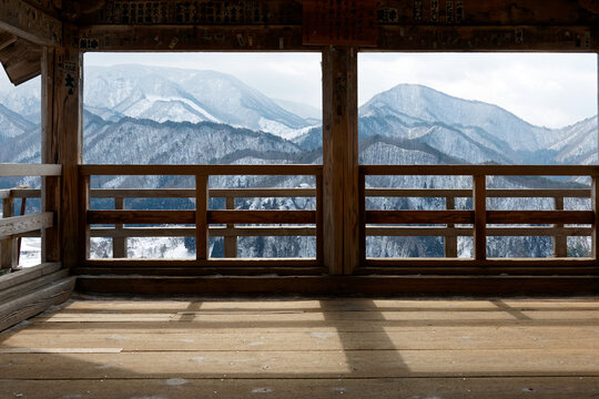 A panoramic view overlooking winter mountains covered with snow from Godaido viewpoint, one of the historic wooden architectures in Rissyaku-Ji 立石寺 Buddhist Temple in Yamadera, Yamagata, Tohoku, Japan