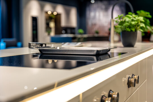 Modern induction hob on white countertop. Stylish kitchen design with lighting.