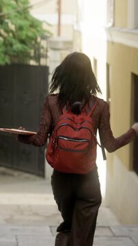 Happy university student dancing down the street