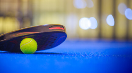 Padel tennis racket with ball. Background with copy space. Sport court and ball. Download a high quality photo with paddle for the design of a sports app or social media advertisement