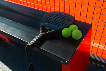 Padel tennis racket with balls. Background with copy space. Sport court and balls. Download a high quality photo with paddle for the design of a sports app or social media advertisement