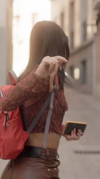 Happy young woman dancing while walking in a city street