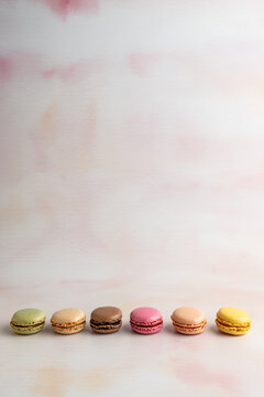 Macaroons lined up in a row on a light surface 