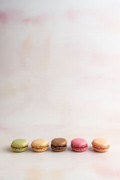 Macaroons lined up in a row on a light surface 