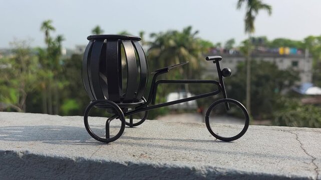 Decorative metal tricycle planter with blurred tropical background, decorative tricycle