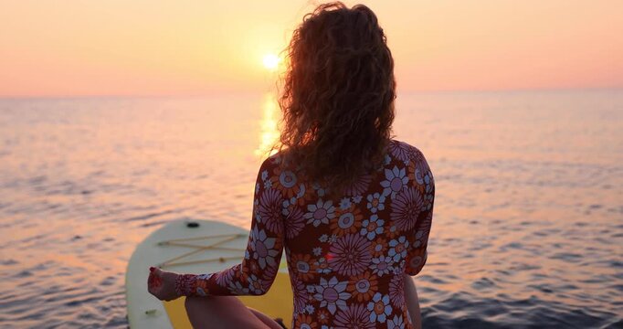 Young woman walking on sup board by the sea during summer vacation. Slow motion