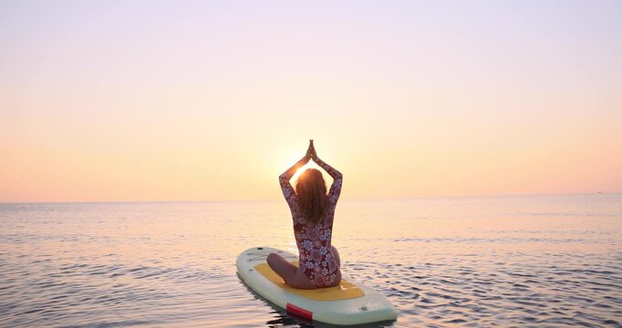 Young woman walking on sup board by the sea during summer vacation. Slow motion