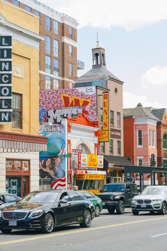 Cars pass by Ben's Chili Bowl with vibrant murals and signage decorating the historic U Street restaurant.