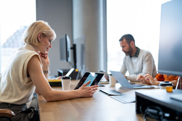 Fototapeta premium Businesswoman watching analytics on digital tablet in office
