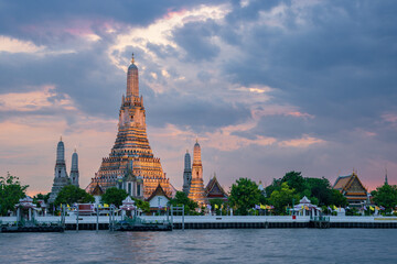 Fototapeta premium Majestic sunset over Wat Arun (Temple of Dawn) along the Chao Phraya River, Bangkok, Thailand