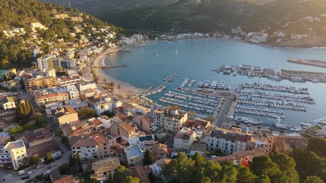 Aerial view of Port de Soller harbor at sunset, beautiful coastal town with mountains and yachts in Mallorca. Golden hour over the Port de Soller and the Tramuntana mountains, Mallorca, Spain
