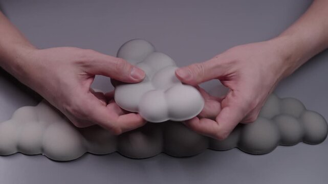 Person testing soft ergonomic cloud shaped mouse wrist rest, showing its memory foam quality and flexibility, promoting comfort and preventing carpal tunnel syndrome.
