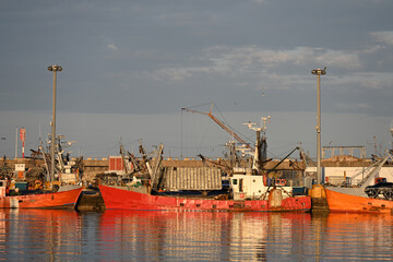 Fototapeta premium fishing boats in port, construction site with crane