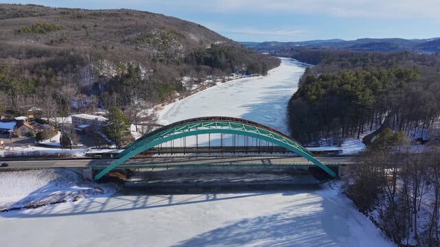 Winter aerial view featuring the United States Navy Seabees Bridge over the frozen Connecticut River Connecting Brattleboro, Vermont and West Chesterfield, New Hampshire