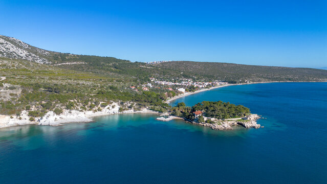 Aerial view of the stunning Manal Bay with crystal clear turquoise water and a small peninsula in Karaburun, Izmir, Turkey.