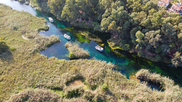 Aerial Top Down View of Crystal Clear Azmak River with Tour Boats and Reeds in Akyaka Turkey