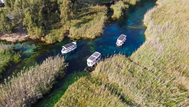 Aerial Top Down View of Crystal Clear Azmak River with Tour Boats and Reeds in Akyaka Turkey