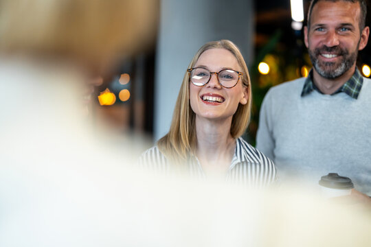 Happy business colleagues smiling and collaborating in office meeting