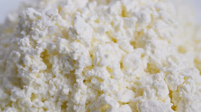 Farmfresh cottage cheese exhibiting wholesome textured appearance, Closeup of soft curds with yellow whey under bright studio lighting demonstrate nutritious eating style