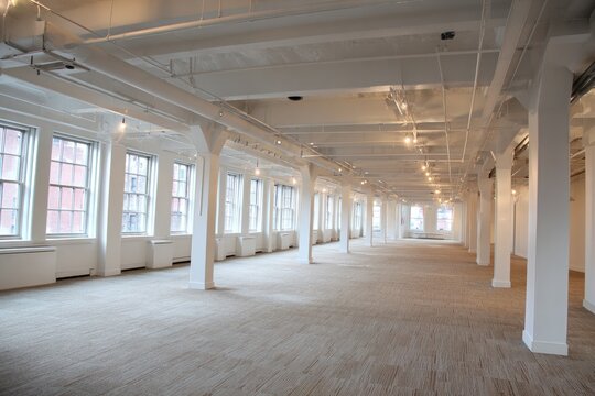 Spacious Industrial Loft Space with Large Windows and Columns.