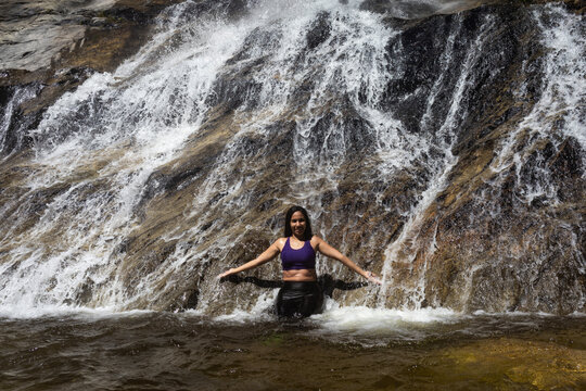 Latina mountaineers in front of a waterfall in the eastern part of Waraira Repano National Park in Guatire. Hiking in Latin America and the Caribbean. Exploring Venezuela