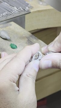 Jeweler sets an emerald into a pendant