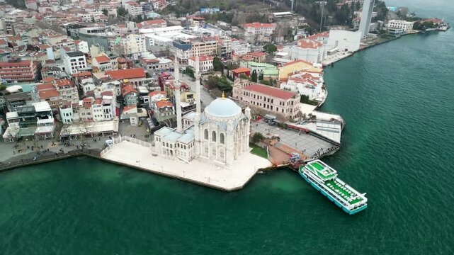 Grand Mecidiye Ortakoy Mosque with martyrs bridge in the back fly above shot