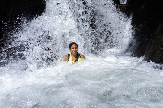 Young women relaxing in a natural river stream in the lush South American tropical forest