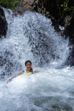 Young women relaxing in a natural river stream in the lush South American tropical forest