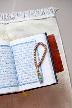 The holy Quran and prayer beads or tasbih on a rehal, capturing a serene atmosphere of devotion