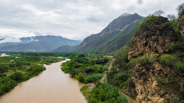 Aerial view of La Leche River winding through green valley with rice fields and mountains in Lambayeque Peru