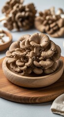 Fototapeta premium Fresh Maitake Mushrooms in a Wooden Bowl on a Cutting Board.