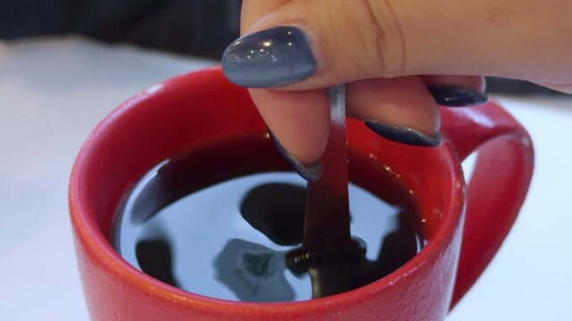Close-up of a woman stirring a hot cup of coffee, morning ritual and slow living concept, 4K ProRes