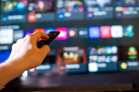 Close-Up of Hand Aiming Remote at Smart TV with Streaming Apps