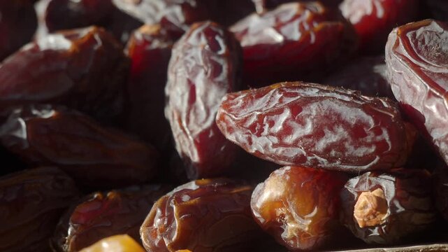 Fresh organic dates heap rotating close up in sunlight for healthy food concept video clip.