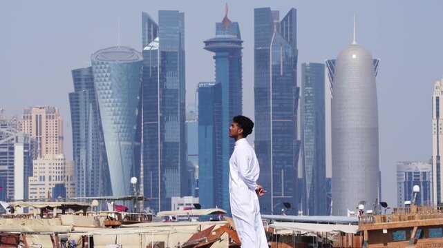 Man in traditional clothing with Doha skyline in background