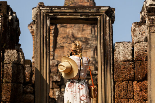 Woman stands framed by ancient stone doorway, Pre Rup, Angkor, Cambodia