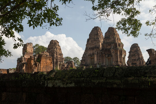 Ancient stone towers rise behind green foliage, Pre Rup, Angkor, Cambodia