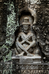 Fototapeta premium Ancient stone carving depicts a seated, crowned figure, Preah Khan, Angkor, Cambodia
