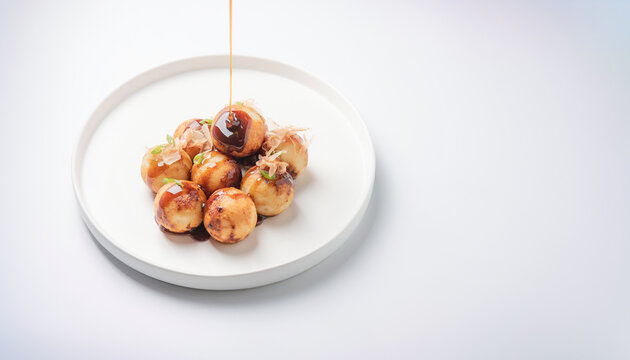 Takoyaki on a plate with sauce being drizzled. ideal for food blogs, restaurant menus, asian cuisine articles.