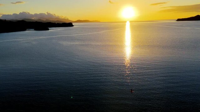 Vuelo de drone revelando playa virgen tropical al atardecer, costa paradis&iacute;aca y monta&ntilde;as en Costa Rica.