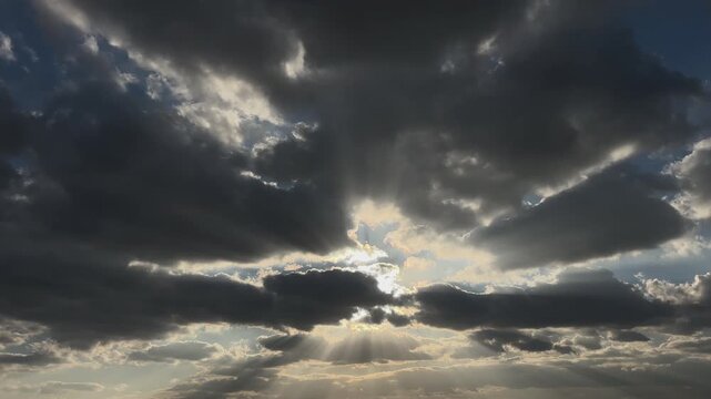 God Rays Through Dark Storm Clouds in Blue Sky, Dramatic Weather Background