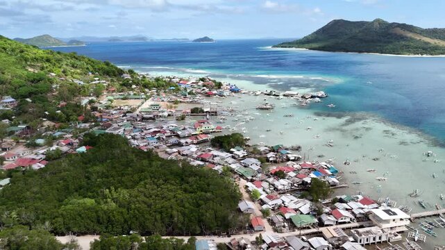 Horizontal panning drone shot over a coastal town in Linapacan with scenic ocean views and island surroundings, Philippines