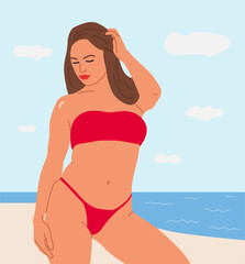 Fototapeta premium Woman in red bikini posing on a beach with blue sky and ocean background