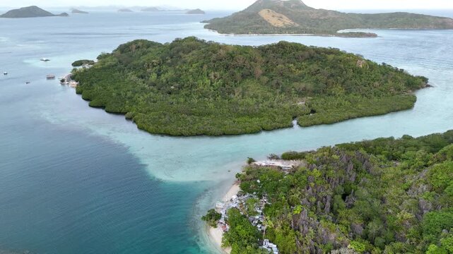 Horizontal panning drone shot of Maapdit Island in the morning, highlighting calm waters and deep to shallow water contrast, Philippines